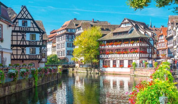 Typical house near water and flowers from La Petite France in Strasbourg, Alsace, France
