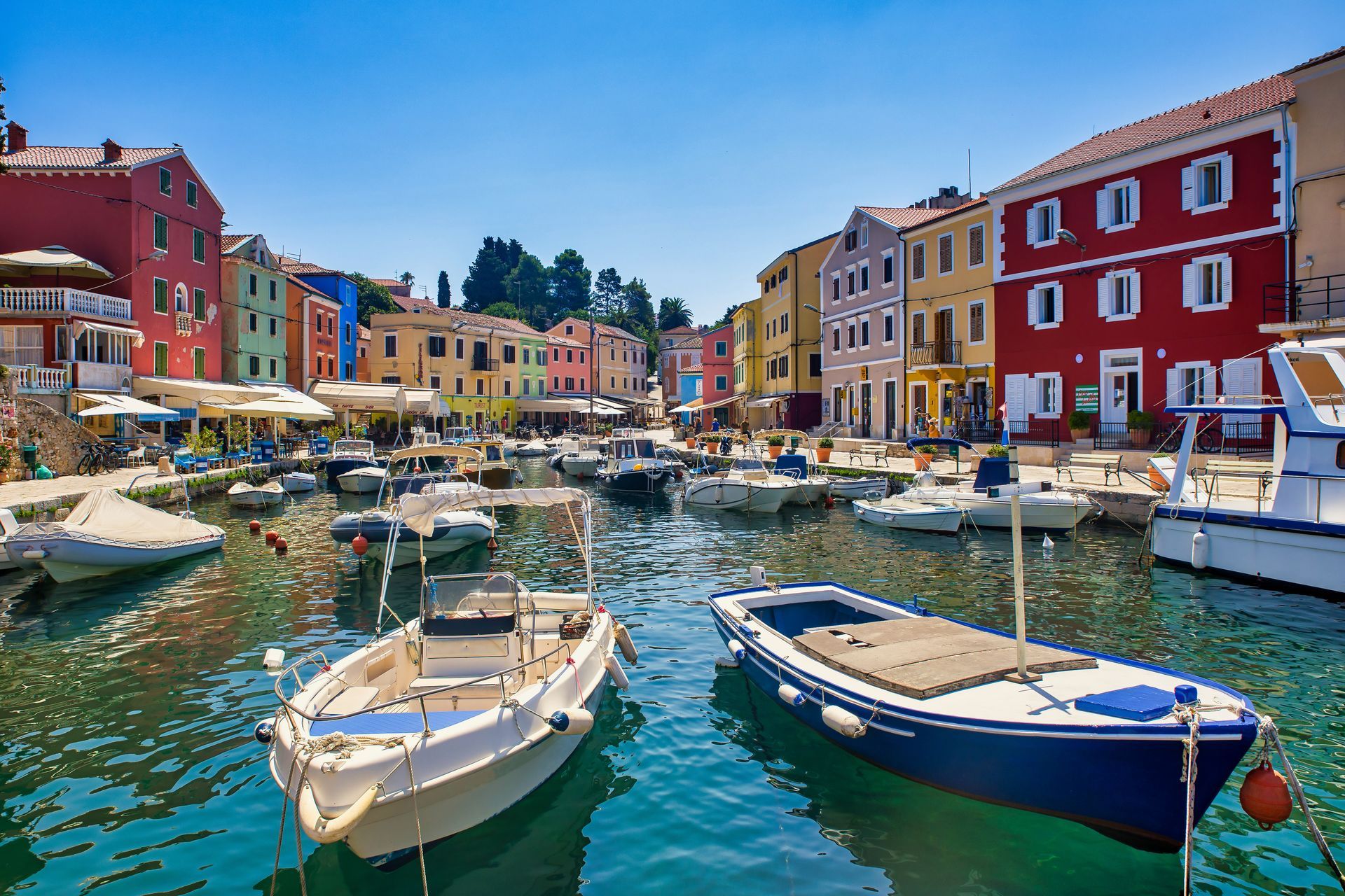 fisher boats and colorful houses in the harbor of veli losinj croatia with sunny blue sky