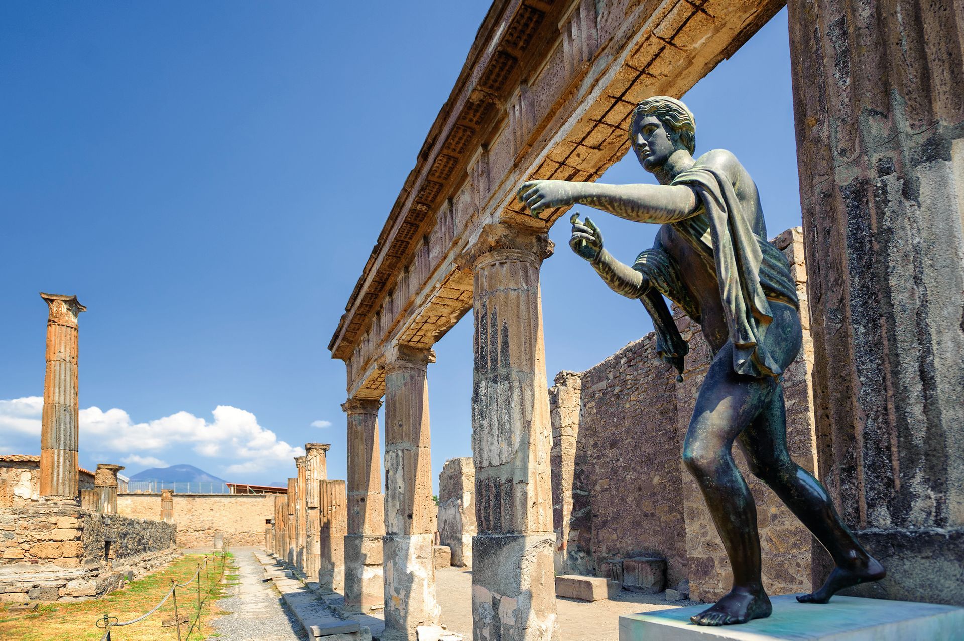 Ruins of the antique Temple of Apollo with bronze Apollo statue in Pompeii, Naples, Italy. Pompeii was destroyed by Vesuvius eruption in 79 AD.